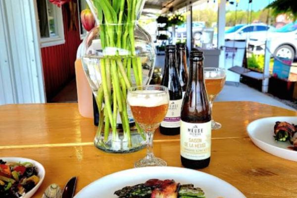 food on a plate with vine and beer on the table at a restaurant